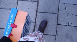 stappende persoon die koffer vast heeft met daarop 'gevoelens'