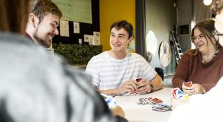 stagiair,jongeren en medewerkers spelen UNO 