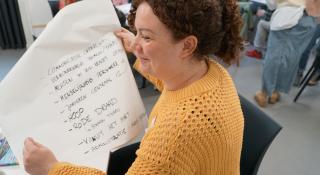 Medewerker heeft flap-over met tekst op vast