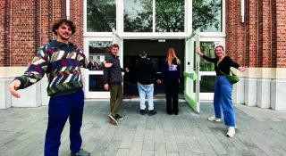 Medewerkers van La Strada verwelkomen en houden de deur open