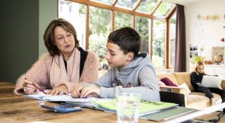 vrijwilliger helpt jongere met huiswerk